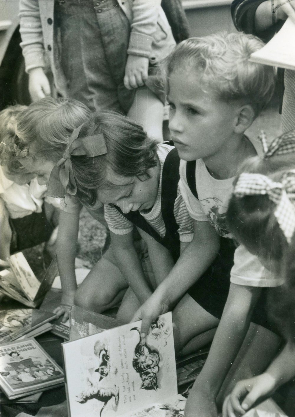 Children reading books from the travelling library for boys and girls