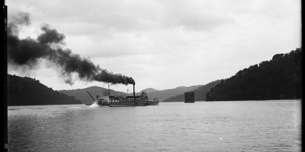 The General Gordon paddle steamer on Hawkesbury River, showing the railway bridge under construction c. 1889